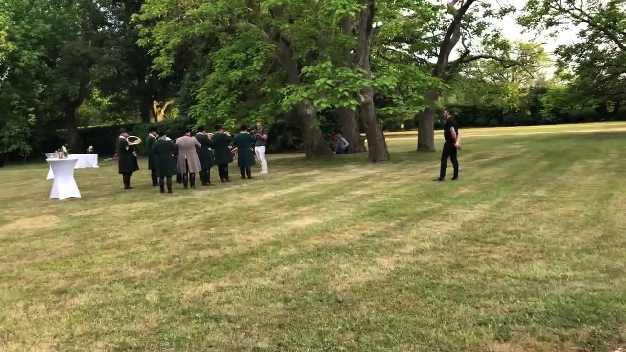 Les sonneurs en tenue verte, group&eacute;s sous les arbres du parc pendant le cocktail