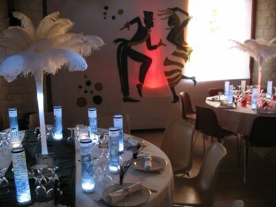Décoration de la salle de mariage sur le thème années folles avec des centre de table en plumes d'autruches